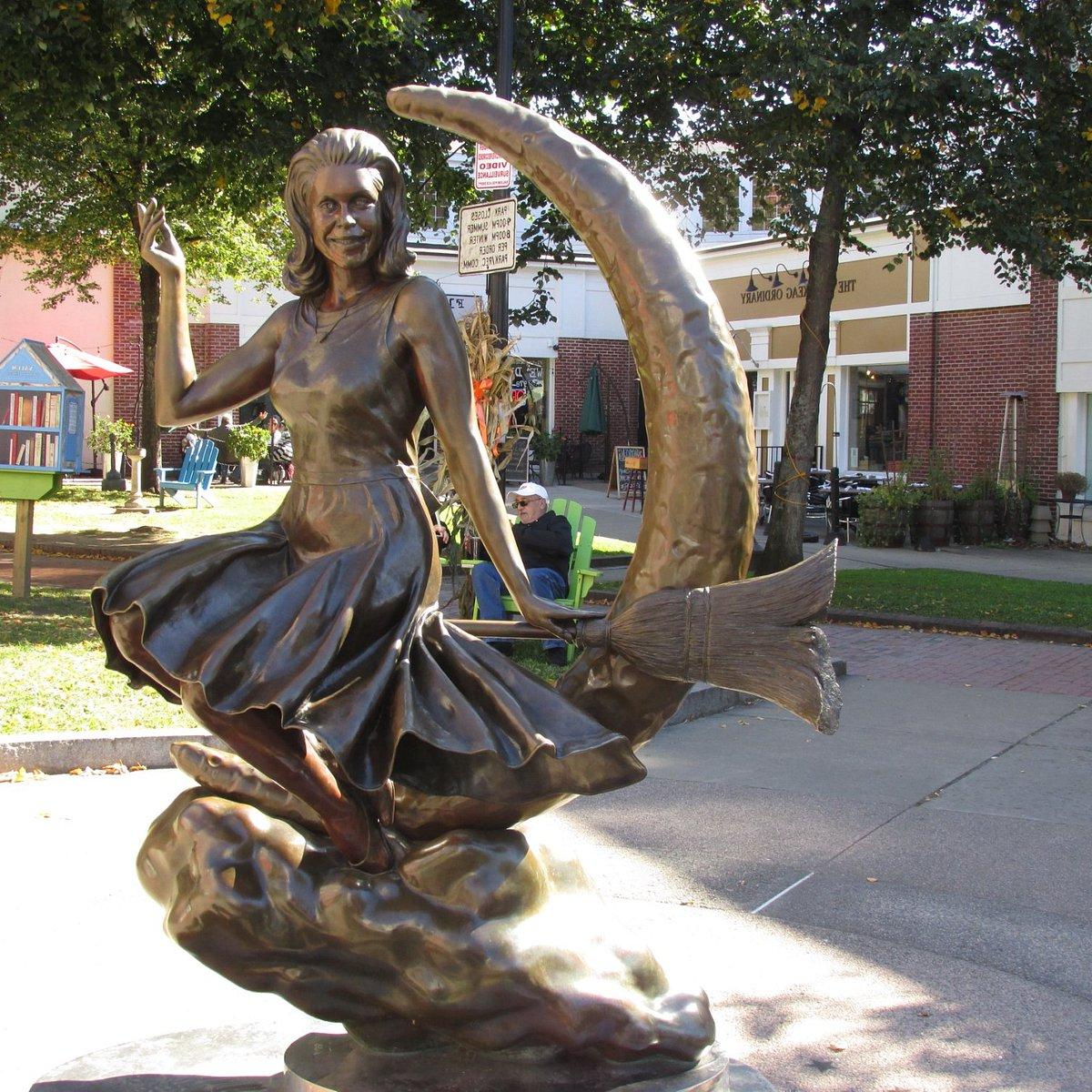 一个女人骑着扫帚站在新月前的青铜雕像
